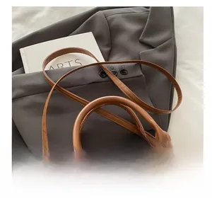 Détail d'un sac vintage marron avec finitions dorées et poignée cylindrique