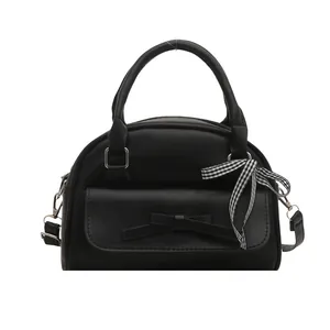 Fashionable black handbag with bow detail and ribbon handle on white background