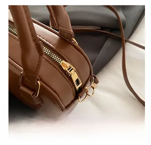 Vue détaillée du zip doré fluide et du cuir marron de qualité supérieure sur le sac