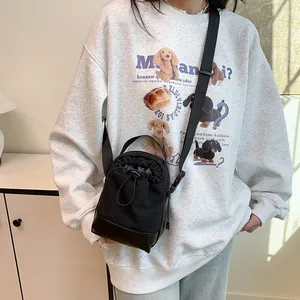 Black drawstring crossbody sports bag with canvas and leather details and wide strap