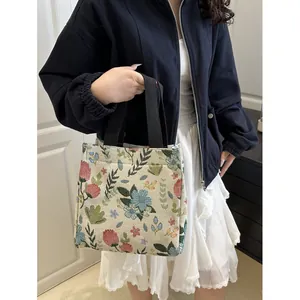Floral tapestry tote bag with black handles in a stylish minimalist interior setting