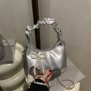 Silver metallic hobo bag with pleated handle, pearl bow charm, and chain strap