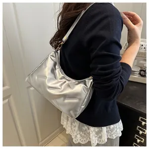 Detail einer silbernen Umhängetasche mit geometrischer Prägung und Metallic-Look