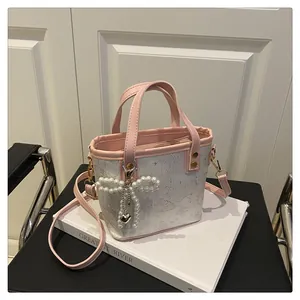 Détail de la poignée en nœud rose et de l'imprimé papillon sur le sac à main