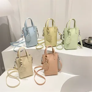 Vertical minimalist bucket bags in pastel colors with cute puppy charms and crossbody straps