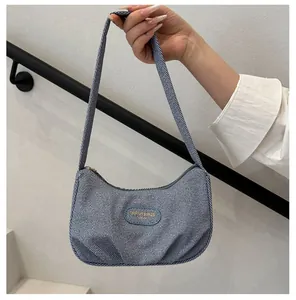 Close-up of hobo bag featuring blue striped fabric and oval logo patch detail