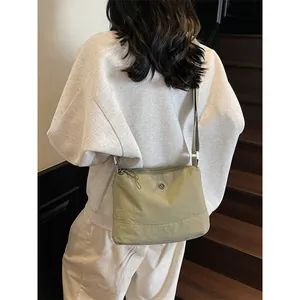 Olive green nylon crossbody bag with adjustable strap and metal logo for casual daily use
