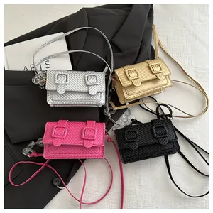 Détail de mini sacs bandoulière en or, argent, rose et noir avec texture en fibre de carbone