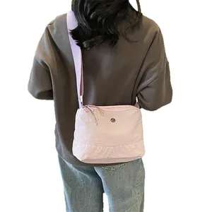 Minimalist light purple nylon crossbody bag for women with wide shoulder strap and metal logo