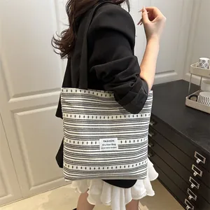 Grand sac cabas en toile rayée pour femme montrant un style décontracté sur le modèle