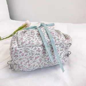 Floral nylon backpack with blue checkered ribbons and pink tulip on a white fabric background