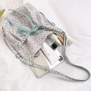 Floral nylon backpack with ruffle trim, drawstring closure and large storage capacity