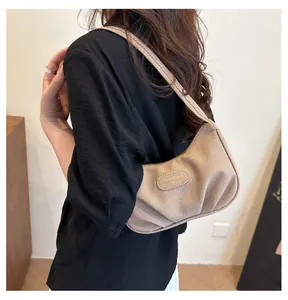 Brown corduroy hobo bag on shoulder showing detailed pleated texture and metal logo