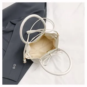 Top view of white bucket bag showing inner yellow lining and magnetic snap closure