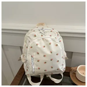 Detailed close-up of cream floral backpack with waterproof fabric and zip compartments