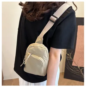Detalle de bolso bandolera de nailon caqui con correa ajustable en modelo femenino
