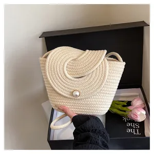 Détail du sac seau tissé main couleur crème avec fermeture à gros bouton perle