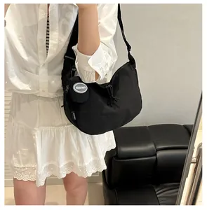 Detail of a black nylon crescent hobo bag with adjustable strap and coin purse attachment