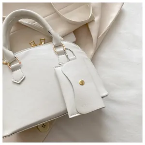 Close-up of cream white PU leather handbag texture with gold metal zippers and mini pouch