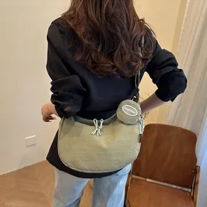 Minimalist olive green nylon crescent tote bag with knot detail and coin purse