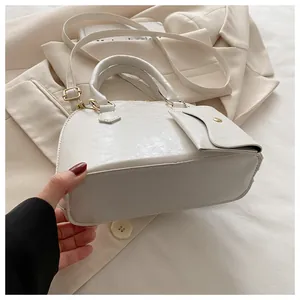 Detail of white glossy shell bag showing texture and matching mini coin purse