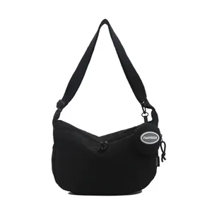 Black nylon crescent crossbody bag with adjustable strap and small round coin purse