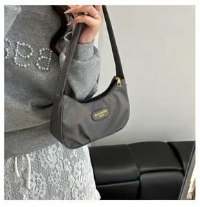 Detail view of the gray textured canvas hobo bag with an oval leather fashion patch