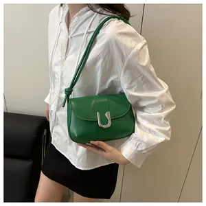 Detail view of grass green leather shoulder bag with glossy silver U-shaped metal buckle