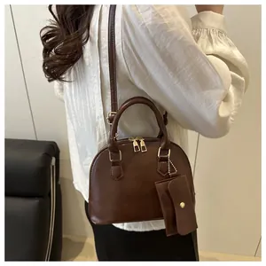 Detail of dark brown shell shoulder bag with adjustable strap and matching coin purse