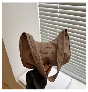 Detail of brown woven hobo bag with oval patch detail and retro textured canvas finish