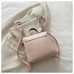 Detail of light pink PU leather backpack with delicate white lace handle and gold hardware