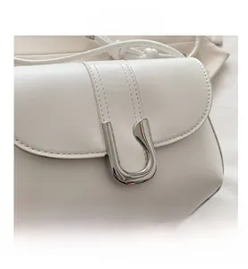 Close-up of the smooth white leather texture and elegant silver U-shaped metal buckle