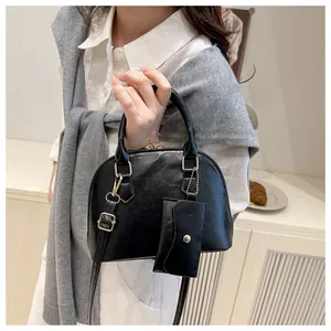 Detail of black shell crossbody bag with detachable strap and matching mini coin purse