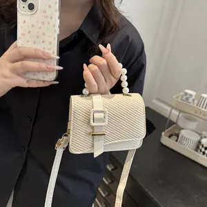 Elegant off-white woven crossbody bag with luxury pearl handle and metallic buckle