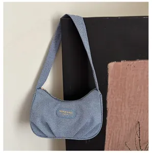 Detail view of the blue textured hobo bag with unique pleated design and shoulder strap
