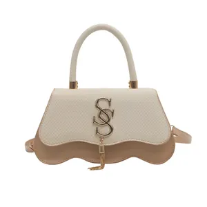 Beige woven crossbody bag with wave bottom and gold SS logo tassel on white background