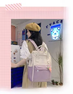 Close-up of beige and purple contrast backpack with front pocket and side bottle pouch