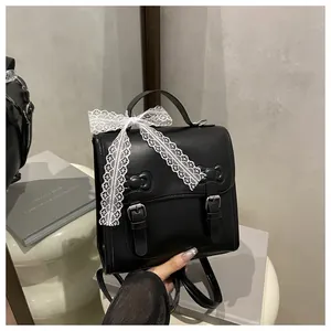 Close-up of black PU leather backpack with white lace bow and vintage buckles