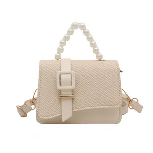 Elegant mini crossbody bag with pearl handle and woven flap in beige finish