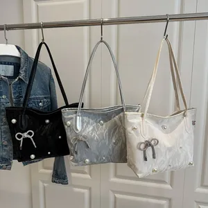 Detailed texture of tote bags with scattered pearls and a rhinestone bow charm