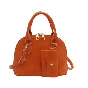 Burnt orange shell shaped handbag with adjustable strap and matching small coin purse