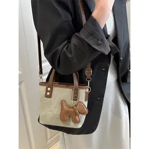 Taupe mini bucket bag with brown leather straps and cute balloon dog charm for women