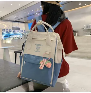 Detail of color-block backpack showing cute strawberry charm and functional pockets