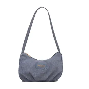 Blue striped crescent shoulder bag with gold zipper and minimalist textured design