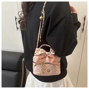 Pink quilted mini bag with floral pendant and silk scarf shown in a crossbody style