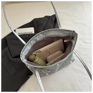 Silver tote bag interior view showing large capacity for laptop and umbrella with pearl bow