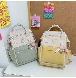 Detail of color-block nylon backpack with ice cream pattern and cute floral pendants