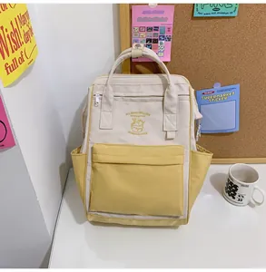 Close-up of lightweight nylon backpack featuring yellow-beige color block and ice cream embroidery