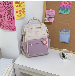 Close-up of canvas backpack details featuring cream and lavender colors with a strawberry charm
