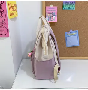 Detail of lavender and cream mini backpack featuring side pockets and metal zippers